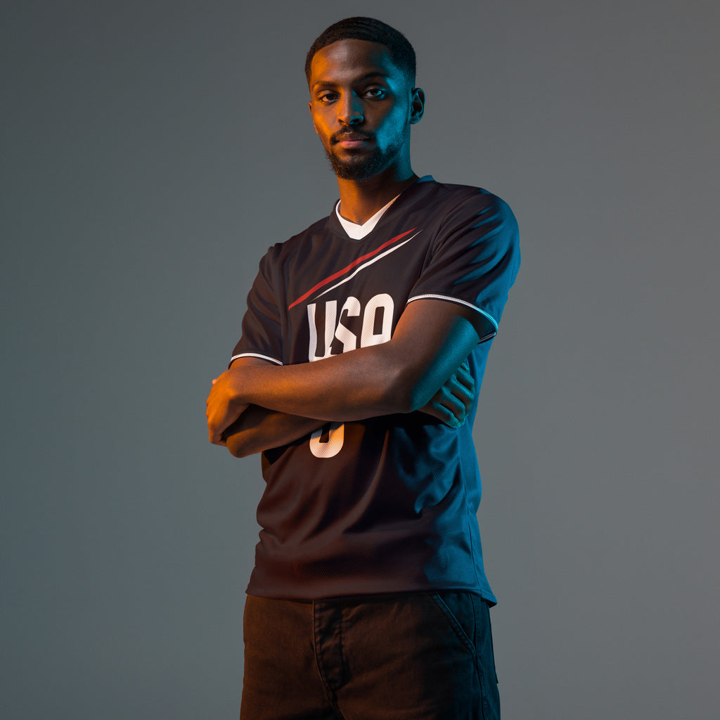 all-over-print-recycled-unisex-sports-jersey-USA-Midnight-Strike-soccer-jersey-navy-base-with-red-and-white-diagonal-strike-premium-national-team-fanwear-male-front-male-model-view
