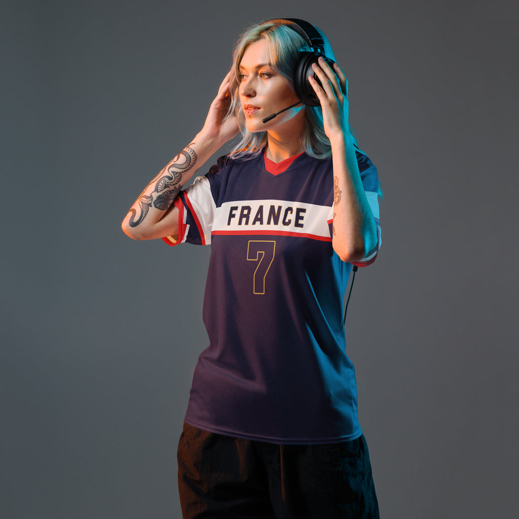 all-over-print-recycled-unisex-sports-jersey-France-Bleu-Majesté-edition-soccer-jersey-royal-blue-base-with-white-chest-band-and-gold-FRANCE-branding-premium-national-team-fanwear-model-front-view-female-model